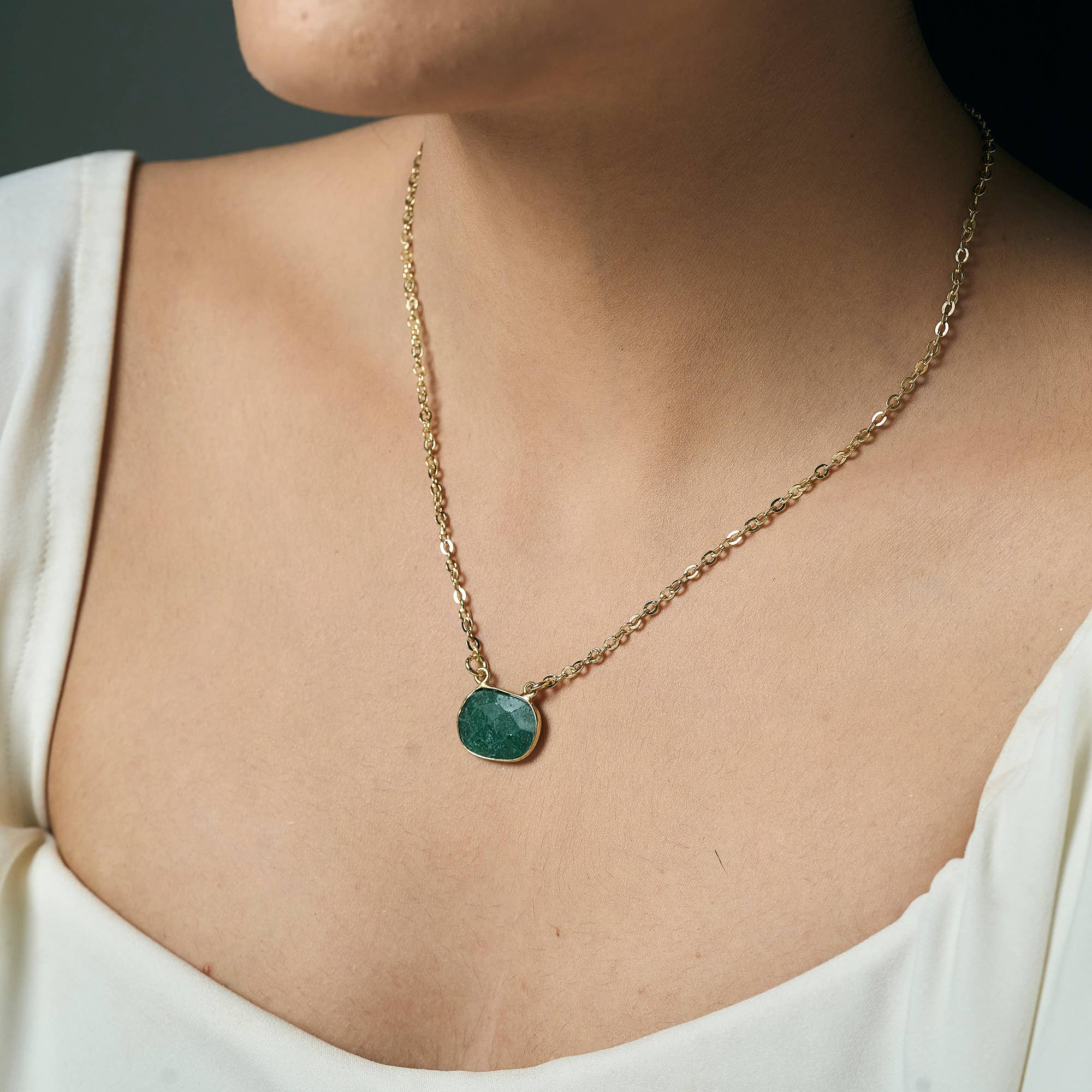 Necklace with a green pendant worn by a person