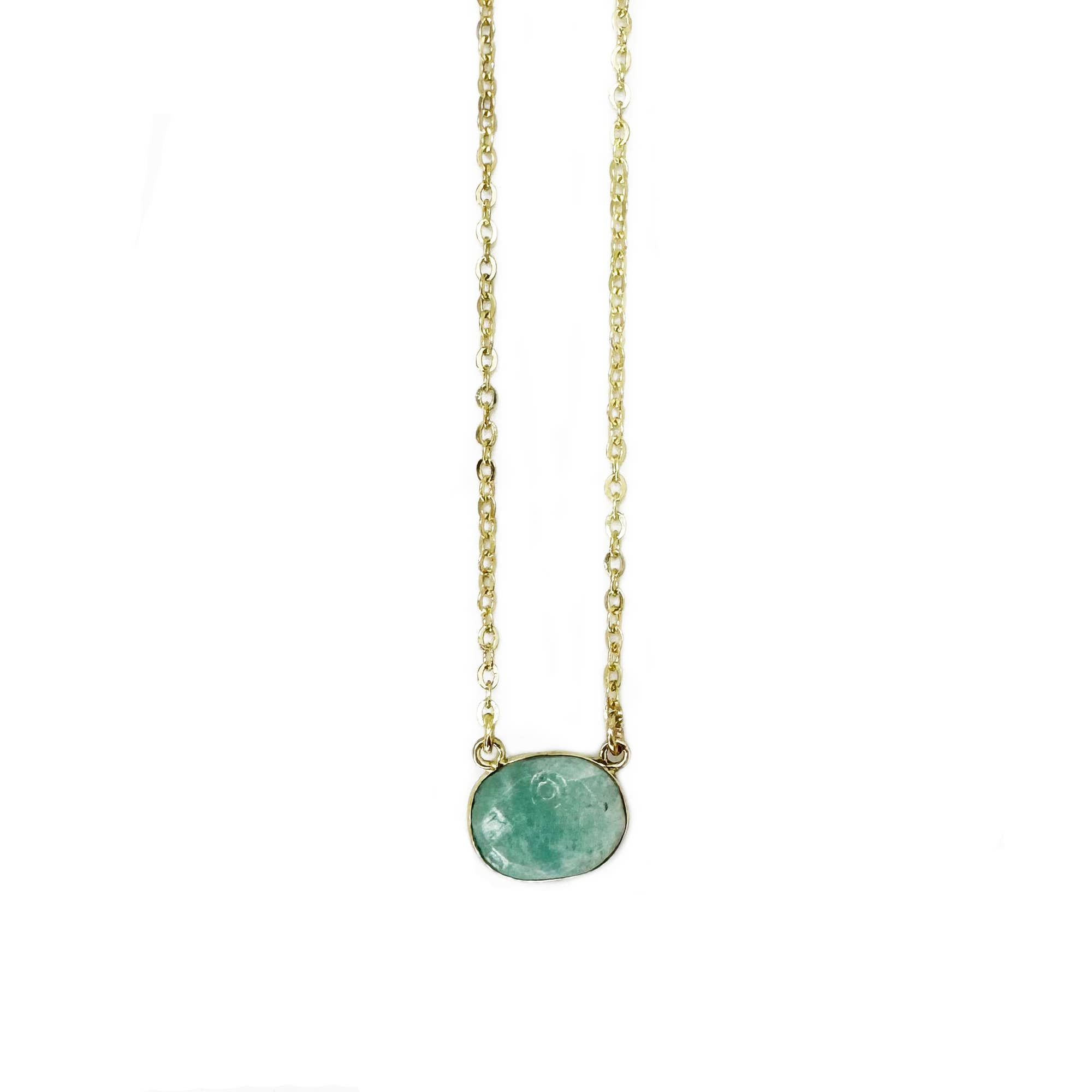 Necklace with a green gemstone pendant on a thin chain against a white background